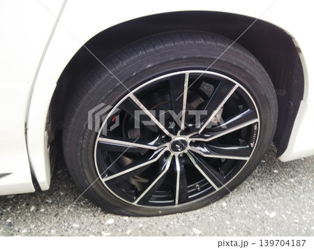 パンクをした白い乗用車のタイヤ パンクをした白い乗用車のタイヤ 139704187