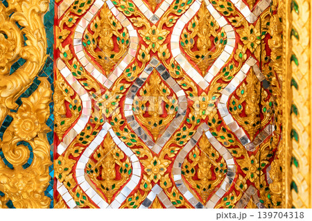 Close view ornate temple door golden thepphanom figure high relief layered carving sacred Thai ornament craftsmanship. Close view ornate temple door golden thepphanom figure high relief layered carving sacred Thai ornament craftsmanship. 139704318