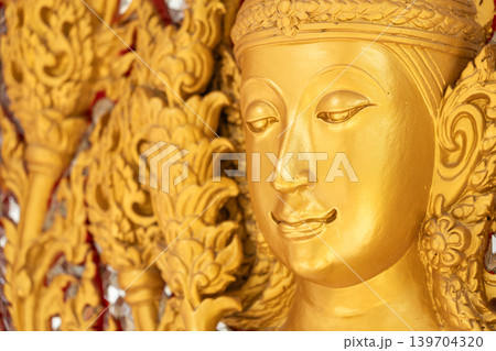 Close view ornate temple door golden thepphanom figure high relief layered carving sacred Thai ornament craftsmanship. Close view ornate temple door golden thepphanom figure high relief layered carving sacred Thai ornament craftsmanship. 139704320