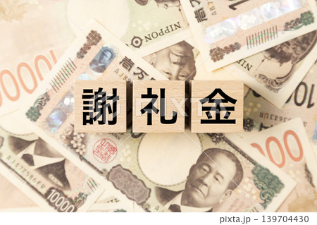 「謝礼金」と書かれたブロックとたくさんの一万円札 「謝礼金」と書かれたブロックとたくさんの一万円札 139704430