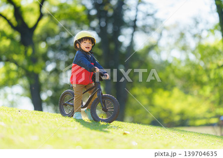 オフロードコースでキックバイクを練習する2歳の男の子 オフロードコースでキックバイクを練習する2歳の男の子 139704635