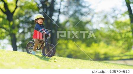 オフロードコースでキックバイクを練習する2歳の男の子 オフロードコースでキックバイクを練習する2歳の男の子 139704636