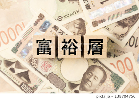 「富裕層」と書かれたブロックとたくさんの一万円札 139704750