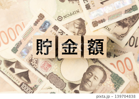 「貯金額」と書かれたブロックとたくさんの一万円札 「貯金額」と書かれたブロックとたくさんの一万円札 139704838