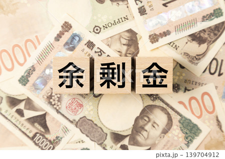 「余剰金」と書かれたブロックとたくさんの一万円札 「余剰金」と書かれたブロックとたくさんの一万円札 139704912