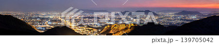Wide panoramic night view of the illuminated city of Madinah in Saudi Arabia taken from the viewpoint at Jabal Uhud under a twilight sky. Wide panoramic night view of the illuminated city of Madinah in Saudi Arabia taken from the viewpoint at Jabal Uhud under a twilight sky. 139705042