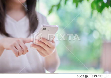 部屋でスマホを見る若い女性 部屋でスマホを見る若い女性 139705682