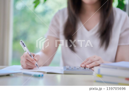 パソコンを見ながら勉強する若い女性 パソコンを見ながら勉強する若い女性 139705696