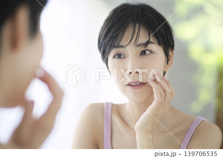 鏡を見ながら肌の状態を確認する女性 139706535
