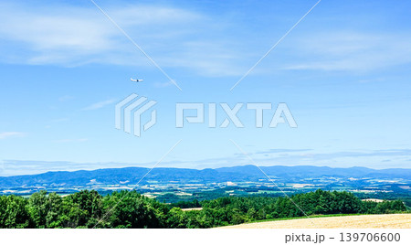 夏の青空の北海道美瑛町周辺の上空を飛ぶ旭川空港に向かう飛行機 139706600