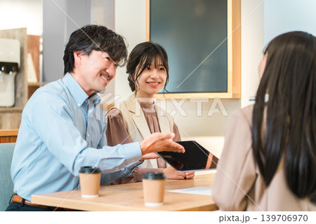 商談スペースのテーブルで商談,打ち合わせをするビジネスマンとビジネスウーマン 139706970