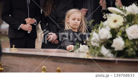 Death, grief and girl at funeral with flower on coffin, family and sad child at service in graveyard for respect. Roses, loss and people at wood casket in cemetery with kid crying at grave for burial Death, grief and girl at funeral with flower on coffin, family and sad child at service in graveyard for respect. Roses, loss and people at wood casket in cemetery with kid crying at grave for burial 139708633