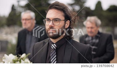 Funeral, death and man carry coffin with family in grief, mourning and sad during church service for peace. Memorial, difficult and person with loss walking in the wind with casket in a ceremony 139708642