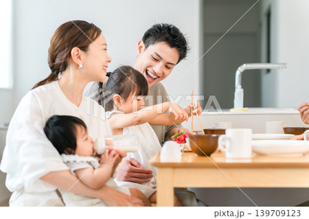 食卓でおままごとをしながらお箸の練習をする女の子と家族,ファミリー 食卓でおままごとをしながらお箸の練習をする女の子と家族,ファミリー 139709123