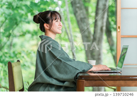 温泉旅館の部屋でパソコンで仕事をする浴衣姿の女性 温泉旅館の部屋でパソコンで仕事をする浴衣姿の女性 139710246