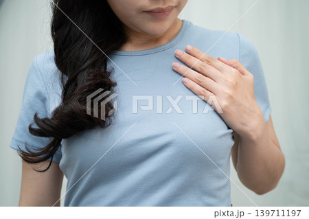 Asian woman self touching check lump or Breast cancer, Breast Self Exam. 139711197