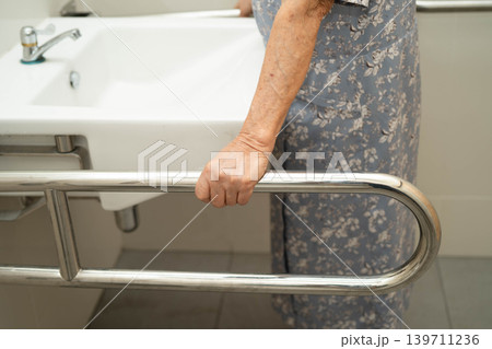 Asian elderly woman use safety handrail in bathroom. Asian elderly woman use safety handrail in bathroom. 139711236