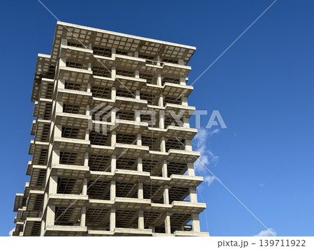 Unfinished concrete building against clear blue sky background Unfinished concrete building against clear blue sky background 139711922