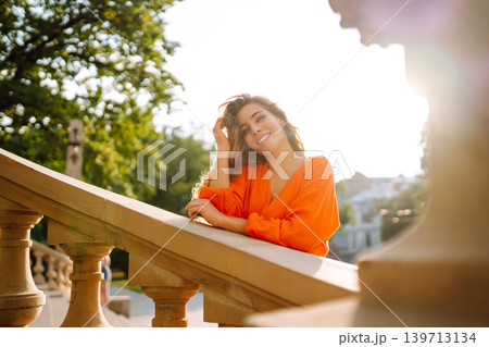 Female tourist in bright dress enjoys sights of the city on sunny day. Concept of lifestyle, fashion 139713134