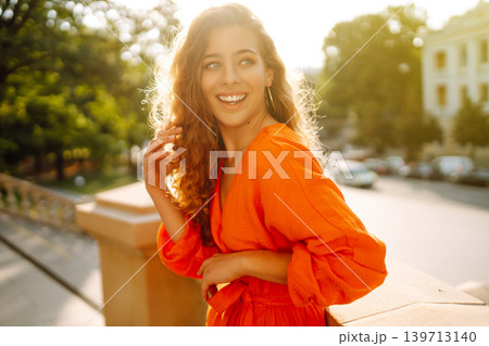 Female tourist in bright dress enjoys sights of the city on sunny day. Concept of lifestyle, fashion 139713140
