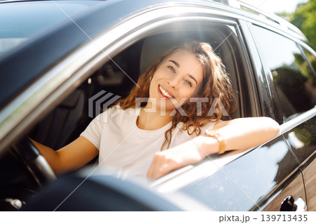 Emotional woman drives a car. The concept of fast movement, traveling by car. 139713435