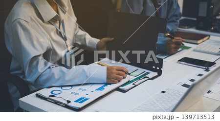 The businesswoman is using a white calculator to check company financial information, she is checking company financial information from the documents provided by the finance department. The businesswoman is using a white calculator to check company financial information, she is checking company financial information from the documents provided by the finance department. 139713513
