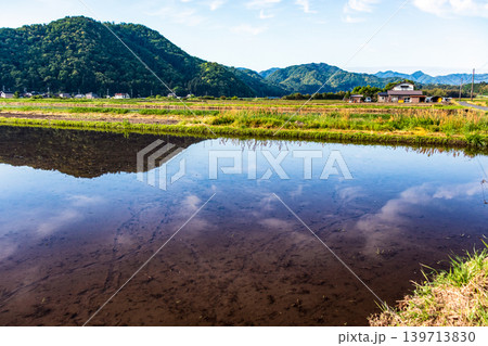 水を張った田植え前の水田に映り込んだ田舎の風景 139713830