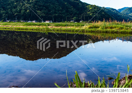 水を張った田植え前の水田に映り込んだ田舎の風景 139713845