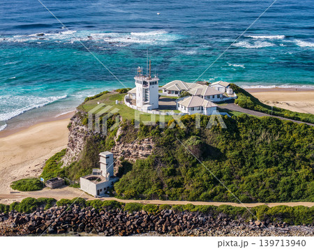 Aerial drone view of Nobbys Beach and the historic Nobbys Lighthouse on the headland at the entrance to Newcastle Harbour. 139713940