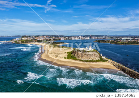 Aerial drone view of Nobbys Lighthouse and sandy Nobbys Beach with Newcastle city skyline and working harbour in the background. Aerial drone view of Nobbys Lighthouse and sandy Nobbys Beach with Newcastle city skyline and working harbour in the background. 139714065