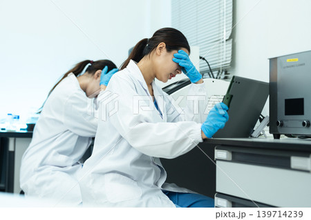 two scientists are under stress from working in research lab. two scientists are under stress from working in research lab. 139714239