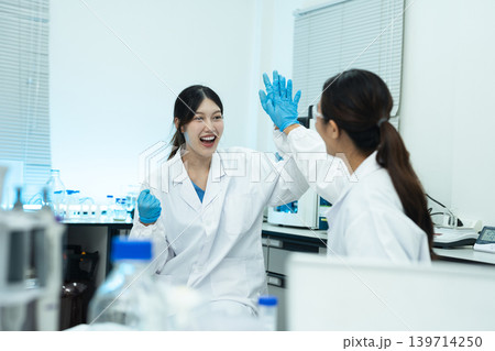 Two researchers in a modern laboratory, successful collaboration, scientific partnership, and innovation in medical research. 139714250