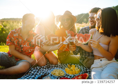 Group of people gathered in garden for picnic. Friends have fun and drink beer. Picnic, friendship. Group of people gathered in garden for picnic. Friends have fun and drink beer. Picnic, friendship. 139714257