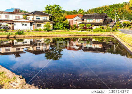 水を張った田植えの前の水田に映り込んだ田舎の風景 139714377