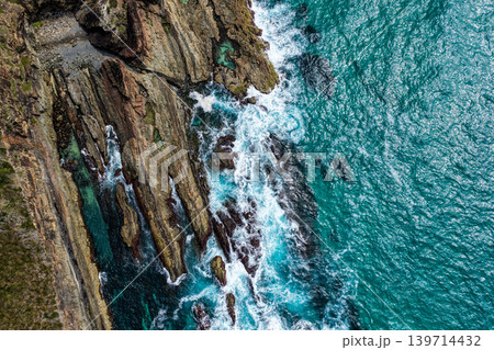 Aerial view of the rocky coastline at McBrides Beach in Forster showing rugged coastal formations, ocean water and natural landscape. The elevated perspective highlights shoreline geology and scenic Aerial view of the rocky coastline at McBrides Beach in Forster showing rugged coastal formations, ocean water and natural landscape. The elevated perspective highlights shoreline geology and scenic 139714432