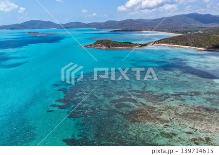 Aerial view over Hydeaway Bay in QLD Australia. Drone photograph captures the tropical coastline, clear ocean water and scenic waterfront landscape from above. 139714615