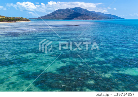 Aerial view over Hydeaway Bay in QLD Australia. Drone photograph captures the tropical coastline, clear ocean water and scenic waterfront landscape from above. Natural Australian coastal environment 139714857