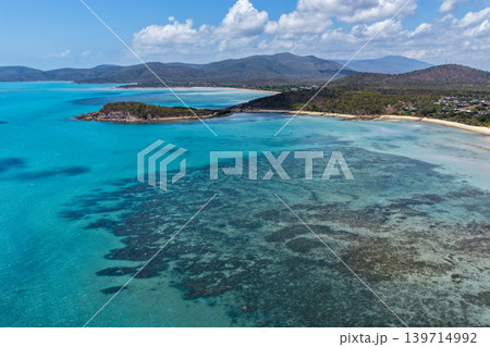 Aerial view over Hydeaway Bay in QLD Australia. Drone photograph captures the tropical coastline, clear ocean water and scenic waterfront landscape from above. Natural Australian coastal environment 139714992