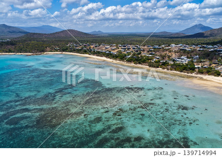 Aerial view over Hydeaway Bay in QLD Australia. Drone photograph captures the tropical coastline, clear ocean water and scenic waterfront landscape from above. Natural Australian coastal environment Aerial view over Hydeaway Bay in QLD Australia. Drone photograph captures the tropical coastline, clear ocean water and scenic waterfront landscape from above. Natural Australian coastal environment 139714994