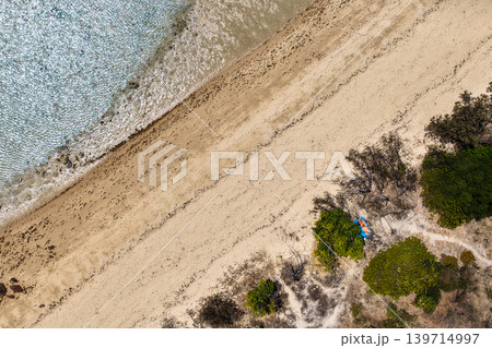 Aerial view over Hydeaway Bay in QLD Australia. Drone photograph captures the tropical coastline, clear ocean water and scenic waterfront landscape from above. Natural Australian coastal environment Aerial view over Hydeaway Bay in QLD Australia. Drone photograph captures the tropical coastline, clear ocean water and scenic waterfront landscape from above. Natural Australian coastal environment 139714997