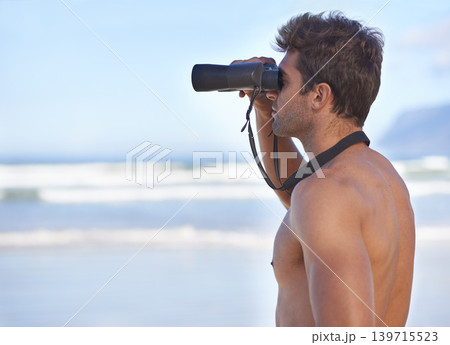 Man, binoculars and lifeguard on beach in search or checking danger for health and safety. Face of male person in fitness for security, bay watch or patrol by the ocean coast or sea in surveillance 139715523