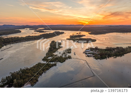 Aerial view of sunset over Wallis Lake in Forster NSW Australia. Drone photograph captures calm waterways, colourful evening sky reflections and the scenic coastal landscape 139716173