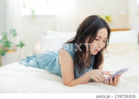 ベッドでスマホを見る女性 139716926