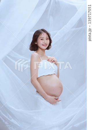 白い布に包まれた妊婦の女性 穏やかなマタニティのイメージ 白い布に包まれた妊婦の女性 穏やかなマタニティのイメージ 139717051