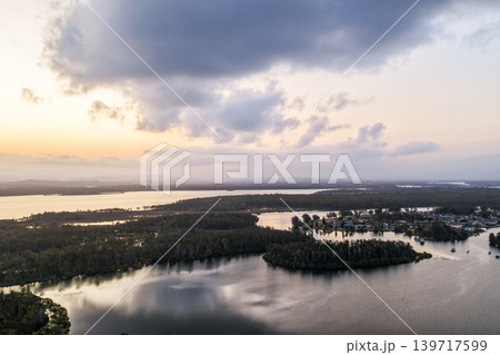 Aerial view of sunset over islands and the Coolongolook River in Tuncurry NSW Australia. Drone photograph captures calm waterways, estuary islands and colourful evening reflections 139717599