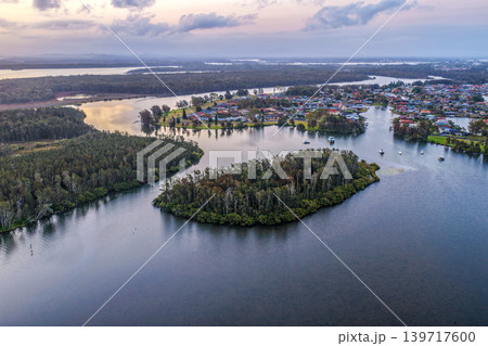 Aerial view of sunset over islands and the Coolongolook River in Tuncurry NSW Australia. Drone photograph captures calm waterways, estuary islands and colourful evening reflections 139717600