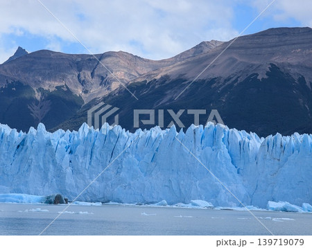 Close view of massive Perito Moreno glacier ice wall with mountain background 139719079