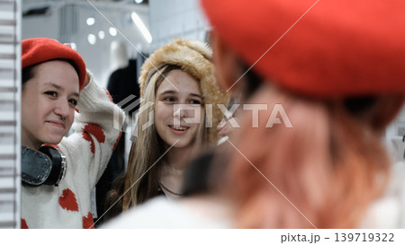 Two teenage friends are shopping for warm winter clothes. 139719322