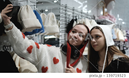 Two teenage friends are shopping for warm winter clothes. 139719323