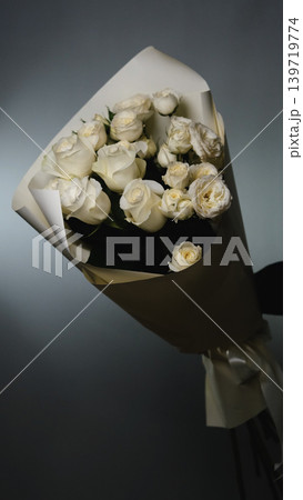 Beautiful white roses in a flower shop. Florist assembles a bouquet to order Beautiful white roses in a flower shop. Florist assembles a bouquet to order 139719774
